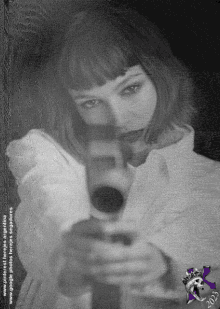 a black and white photo of a woman holding a gun with the year 2003