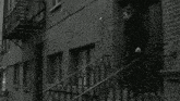 a black and white photo of a man walking up the stairs