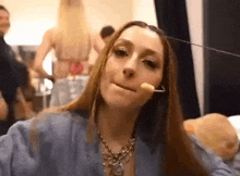 a woman with long hair is making a funny face while wearing a necklace and earrings .