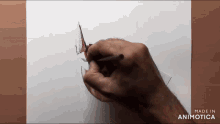 a hand is drawing a triangle on a piece of paper with the words made in animotica below it