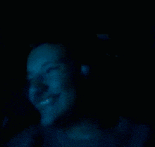 a man wearing headphones looks at the camera in a dark room .