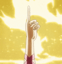 a hand with a pink ribbon on it is pointing up in the air