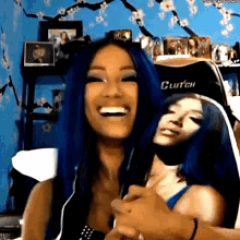 a woman with blue hair is laughing while holding another woman 's hand .