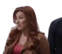 a woman with red hair is standing next to a man in a blue shirt .