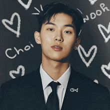 a man in a suit and tie is surrounded by hearts and the word choi written on a blackboard