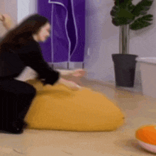 a woman sitting on a yellow bean bag chair