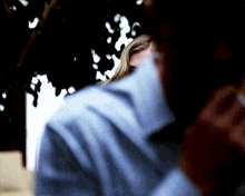 a blurry picture of a woman behind a man 's shirt
