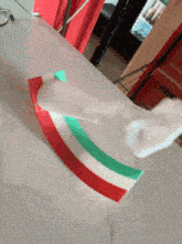 a red white and green striped object is sitting on a table