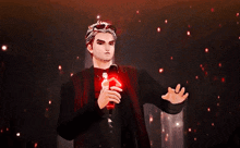 a man in a black suit is holding a red object in his hands