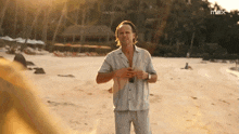 a man standing on a beach with the word max on the bottom right
