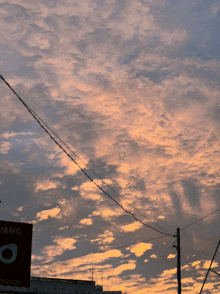 a cloudy sky with a sign in the foreground that says ' o '