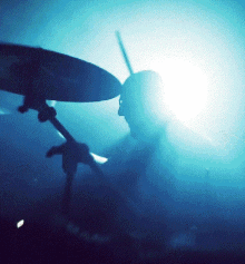 a person playing drums in a dark room