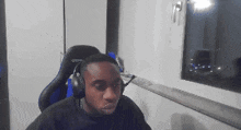 a man wearing headphones is sitting in front of a window ..