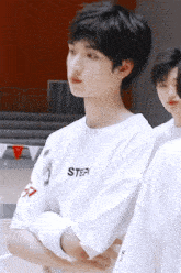 a boy wearing a white shirt that says step