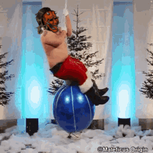 a man dressed as santa claus is riding a blue ball