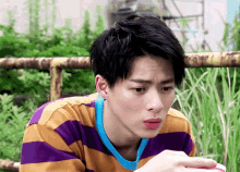a young man in a purple and yellow striped shirt