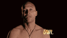 a man without a shirt stands in front of a fire