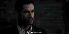 a man in a suit and white shirt is asking do you trust me