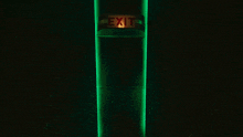 an exit sign is lit up on a green pole