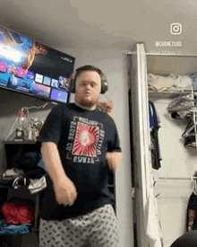 a man wearing headphones is dancing in front of a tv