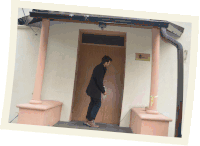 a man stands in front of a door that has a sign on it that says ' embassy of mexico '
