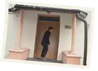 a man stands in front of a door that has a sign on it that says ' embassy of mexico '