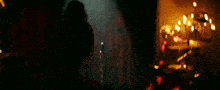 a woman in a red dress is holding a microphone in a dark room