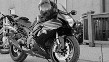 a black and white photo of a suzuki motorcycle with a helmet on top of it