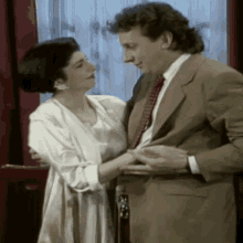 a man and a woman are standing next to each other in a room
