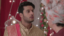 a man with a red bindi on his forehead looks at another man