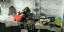 a woman is cooking in a kitchen with a wall with eyes on it