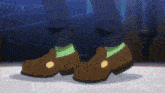 a person wearing a pair of brown shoes with a yellow circle on the toe