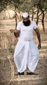 a man with a beard wearing a white shirt and a white hat