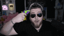 a man wearing sunglasses and headphones holds a toy gun in his hand