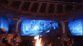a crowd of people are watching a show on a large screen .