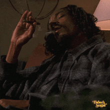 a man in a plaid shirt is smoking a cigar with the words brown sugar on the bottom left