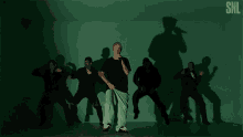 a group of people are dancing in front of a snl sign