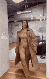 a woman is wearing a trench coat and a corset