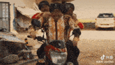a group of men are riding a red motorcycle with the number 6157308 on the bottom of the screen