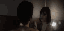 a woman with a tattoo on her shoulder is looking at herself in a mirror