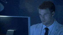 a man giving a thumbs up in front of a computer
