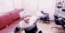 a young man sitting in a room with a sign that says bts bomb on it