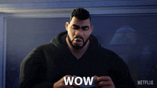 a man with a beard is holding something in his hands and the word wow is on the screen