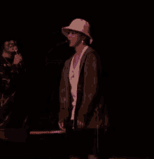 a man in a cowboy hat is dancing on a stage in front of a microphone .
