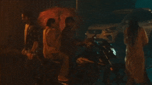 a group of people standing around a motorcycle and a car