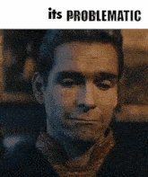 a man with a scarf around his neck is making a funny face .