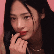 a close up of a woman 's face with her hand on her mouth