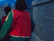 a man in a red shirt with the letter s on it is carrying another man