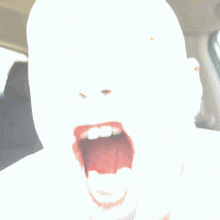 a close up of a man 's face with his mouth wide open