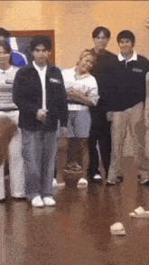 a group of young people are standing next to each other on a wooden floor .